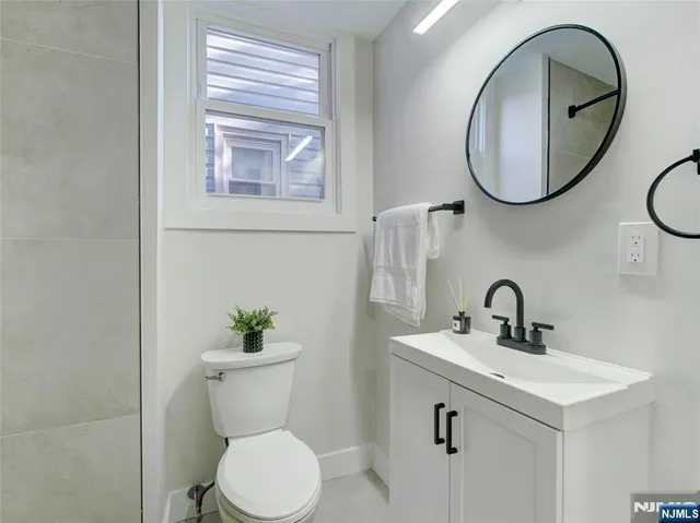 a bathroom with a toilet sink and mirror