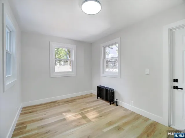 a view of room with window and wooden floor
