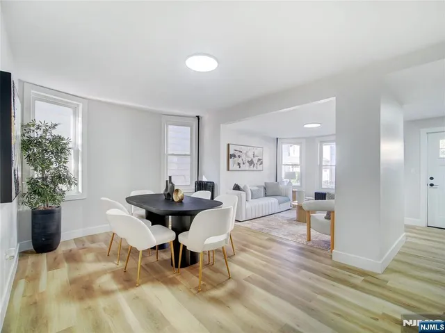 a living room with furniture a window and a potted plant