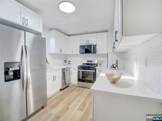 a kitchen with stainless steel appliances a refrigerator sink and stove