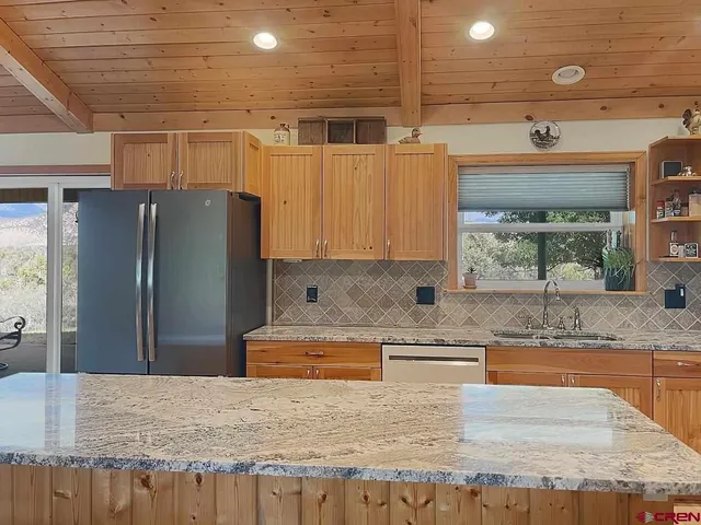 a kitchen with stainless steel appliances granite countertop wooden cabinets and a granite counter tops