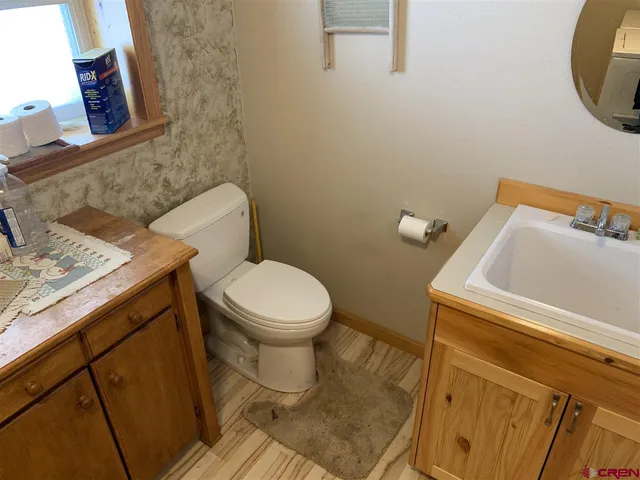 a white toilet sitting next to a bathroom sink and vanity