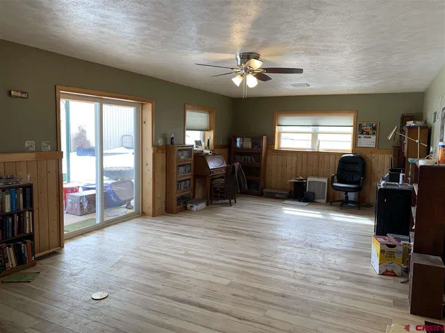 a view of a livingroom with furniture cabinet wooden floor and windows