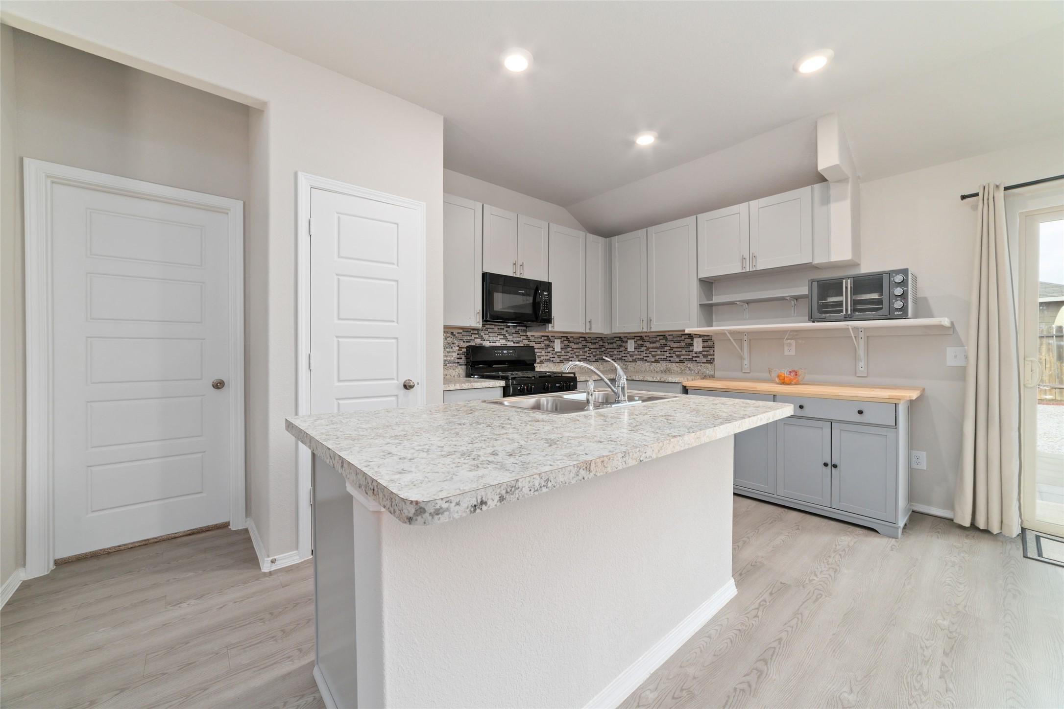 14232 Shasta Ridge Drive Conroe, TX 77303 - Photo 11 of 26 Spacious kitchen with an oversized island and high ceilings, seamlessly connecting to the surrounding living spaces.