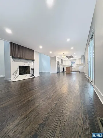 a kitchen with stainless steel appliances granite countertop a sink a stove a refrigerator and island with wooden floor