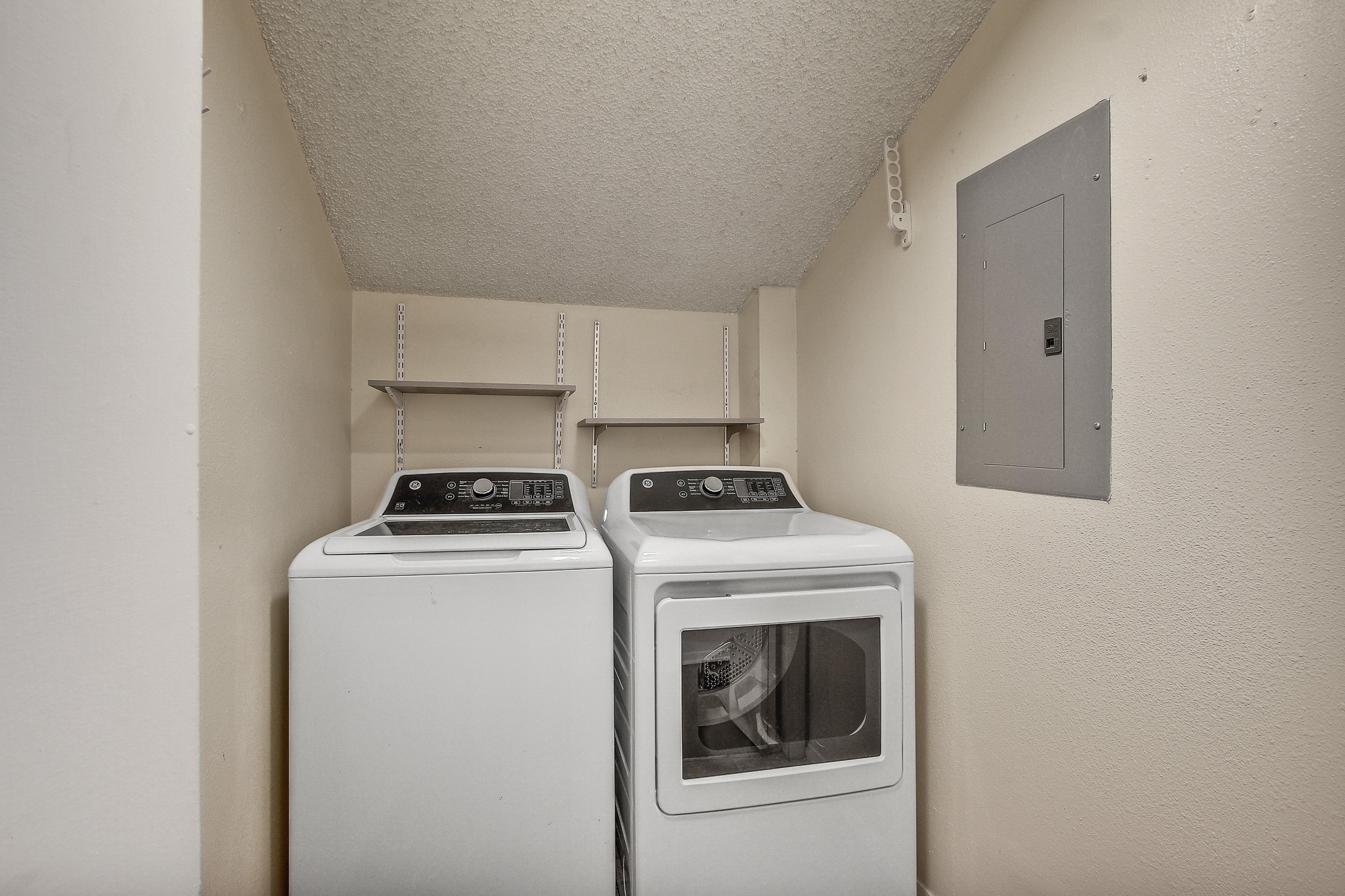 8925 North Plaza, Unit 69 Austin, TX 78753 - Photo 19 of 29 Washroom with electric panel, separate washer and dryer, and a textured ceiling