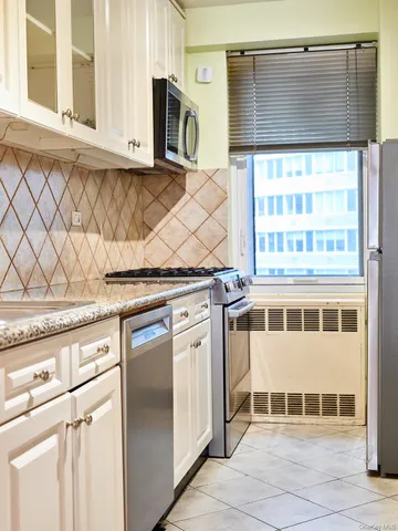 a kitchen with stainless steel appliances granite countertop a stove and a microwave