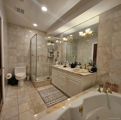 a bathroom with a double vanity sink toilet and shower