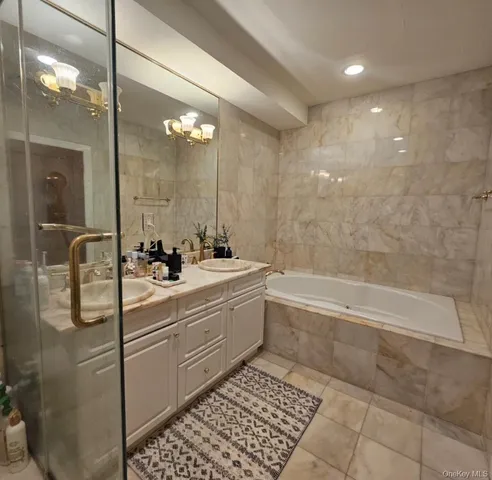 a bathroom with a double vanity sink a mirror and a bathtub
