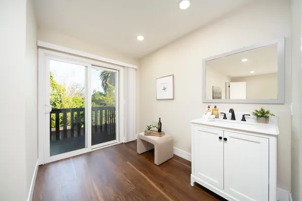a room with a white bed couches with wooden floor