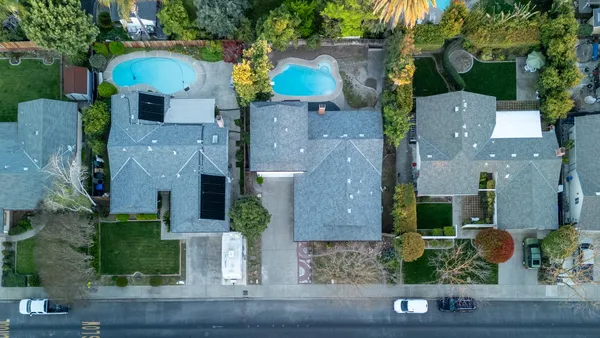an aerial view of multiple houses with a yard