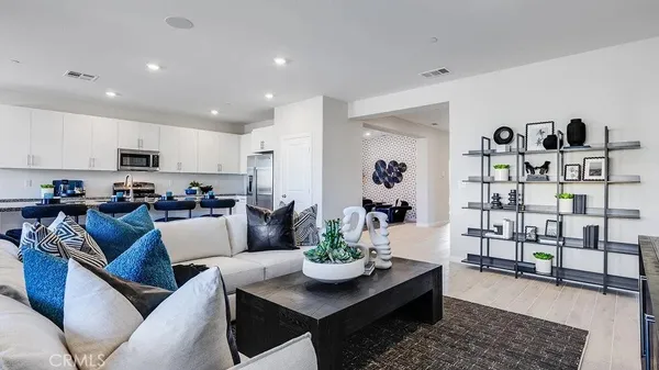 a living room with furniture kitchen view and wood floor