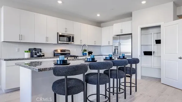 a kitchen with stainless steel appliances granite countertop a table and chairs in it