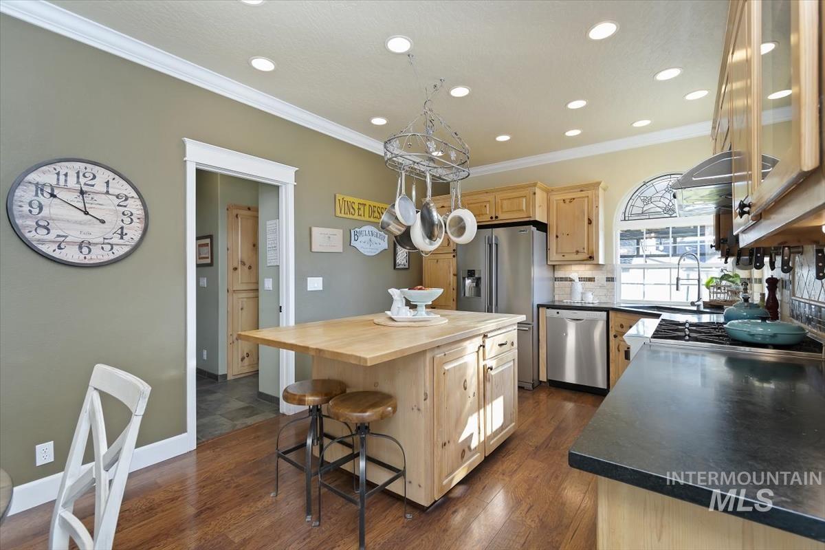 14111 Towers Drive Caldwell, ID 83607 - Photo 12 of 50 Kitchen featuring light brown cabinets, wooden counters, a kitchen breakfast bar, stainless steel dishwasher, and ornamental molding