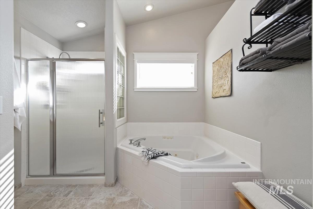14111 Towers Drive Caldwell, ID 83607 - Photo 25 of 50 Bathroom featuring a stall shower, a tub with jets, and lofted ceiling