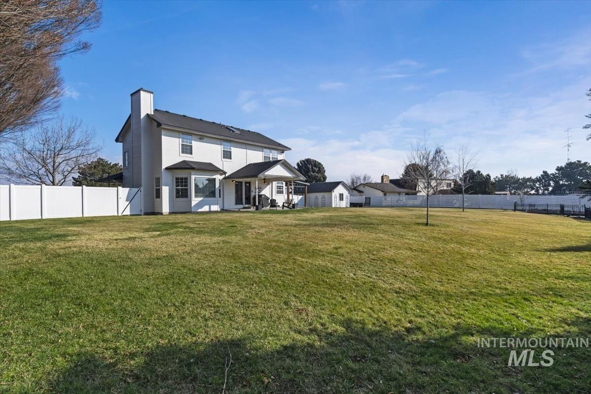 14111 Towers Drive Caldwell, ID 83607 - Photo 31 of 50 Rear view of house with a fenced backyard and a chimney