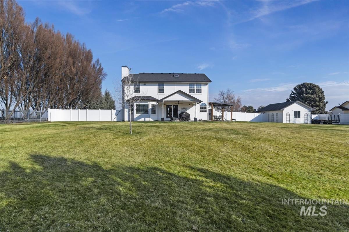 14111 Towers Drive Caldwell, ID 83607 - Photo 32 of 50 Rear view of property featuring a fenced backyard, a chimney, and a patio