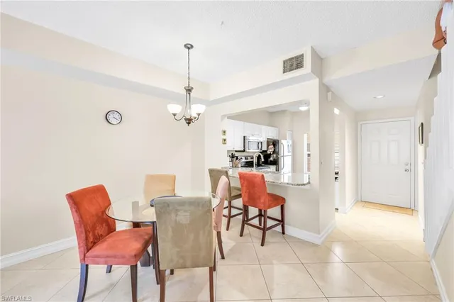 a kitchen with stainless steel appliances a sink a refrigerator a window and cabinets