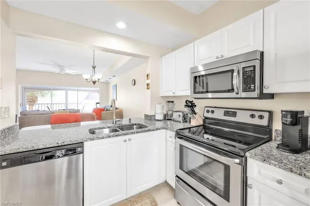 a kitchen with appliances a refrigerator a sink and cabinets