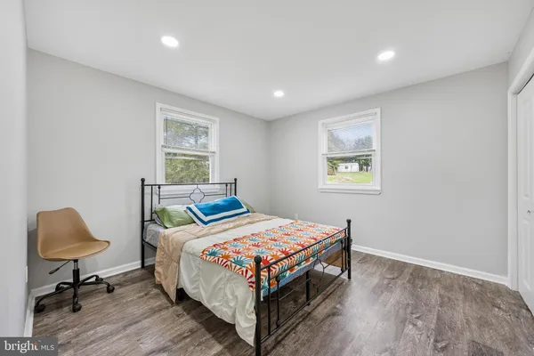 a bedroom with a bed and a lamp on dresser