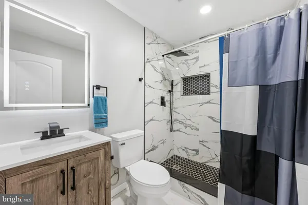 a bathroom with a sink toilet vanity and shower