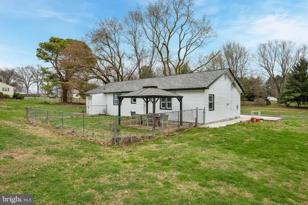 a view of a house with backyard and trees