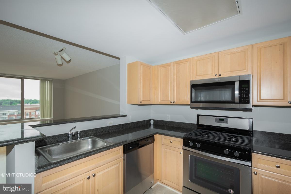 2726 Gallows Road, Unit 1202 Vienna, VA 22180 - Photo 7 of 24 a kitchen with granite countertop a sink stainless steel appliances and cabinets