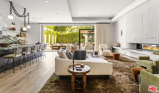a living room with fireplace furniture and a large window