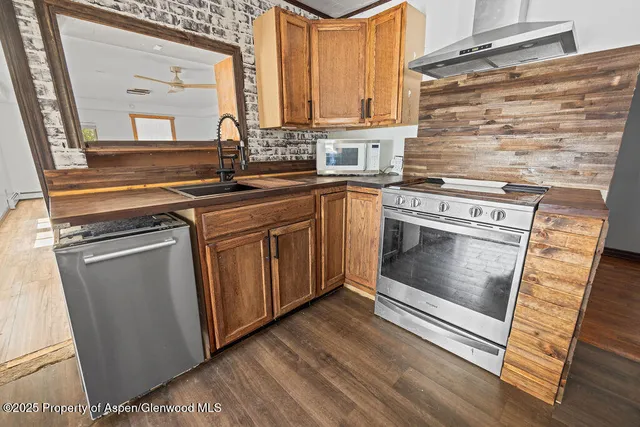 a kitchen with granite countertop a stove a sink and a microwave