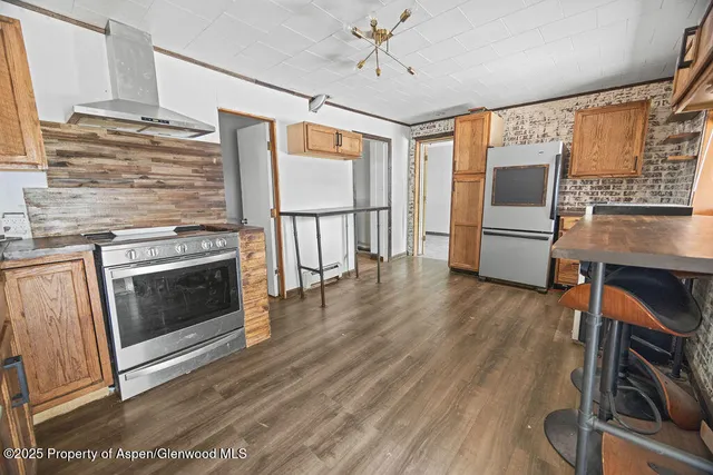 a view of a livingroom with wooden floor and a ceiling fan