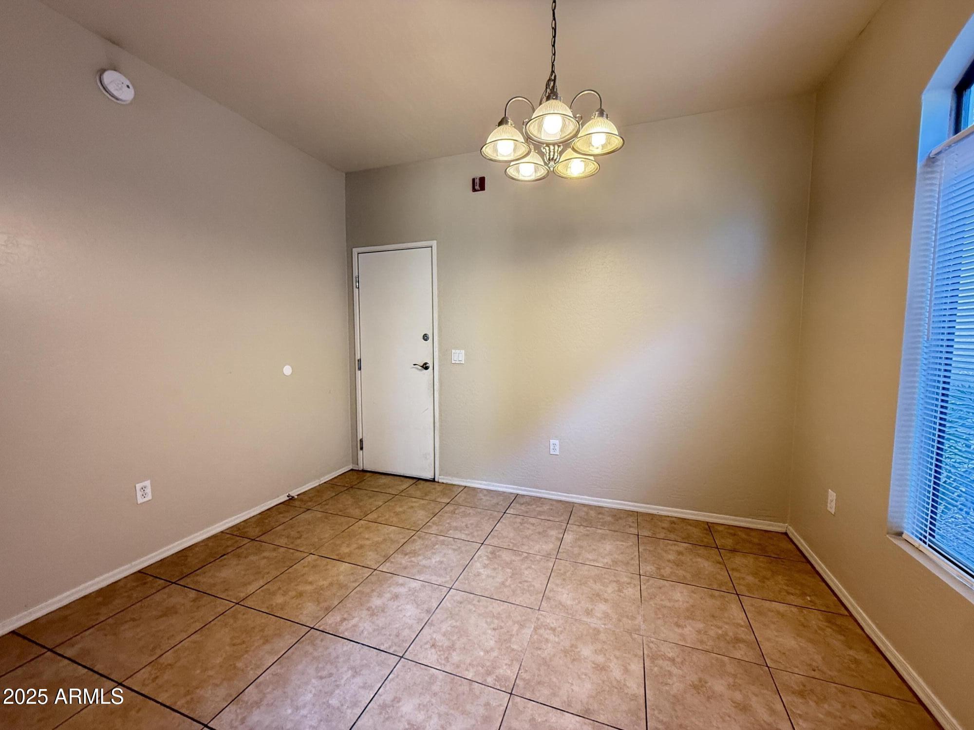 2150 East Bell Road, Unit 1138 Phoenix, AZ 85022 - Photo 13 of 38 a view of an empty room with a chandelier fan