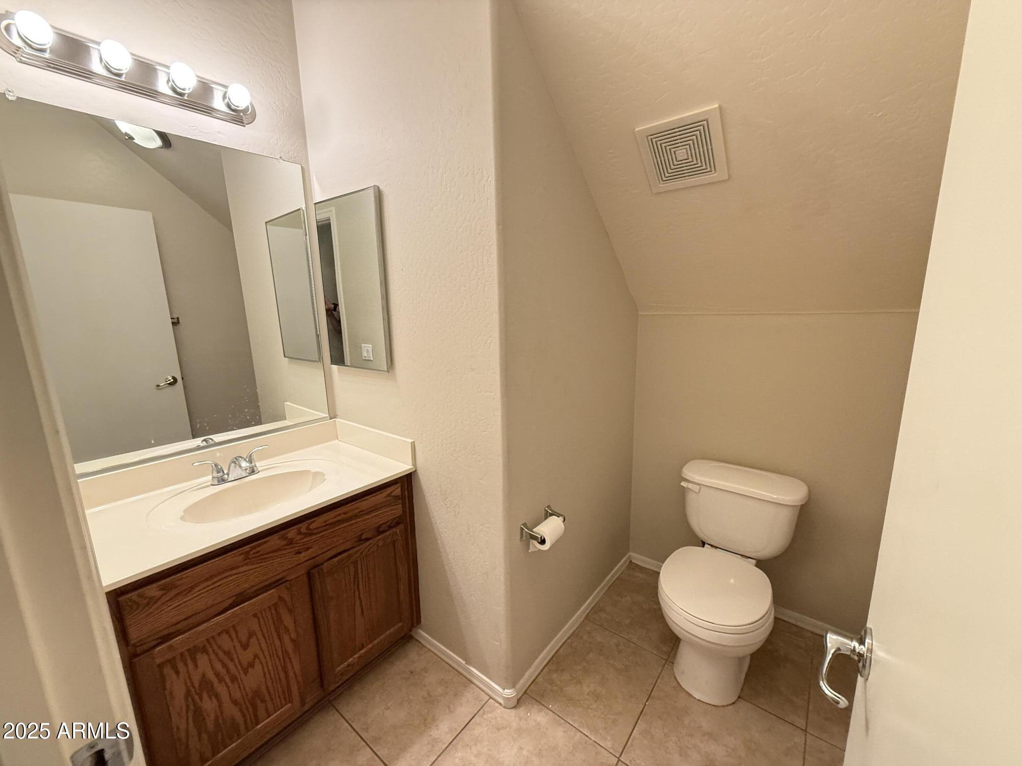 2150 East Bell Road, Unit 1138 Phoenix, AZ 85022 - Photo 18 of 38 a bathroom with a toilet sink and mirror