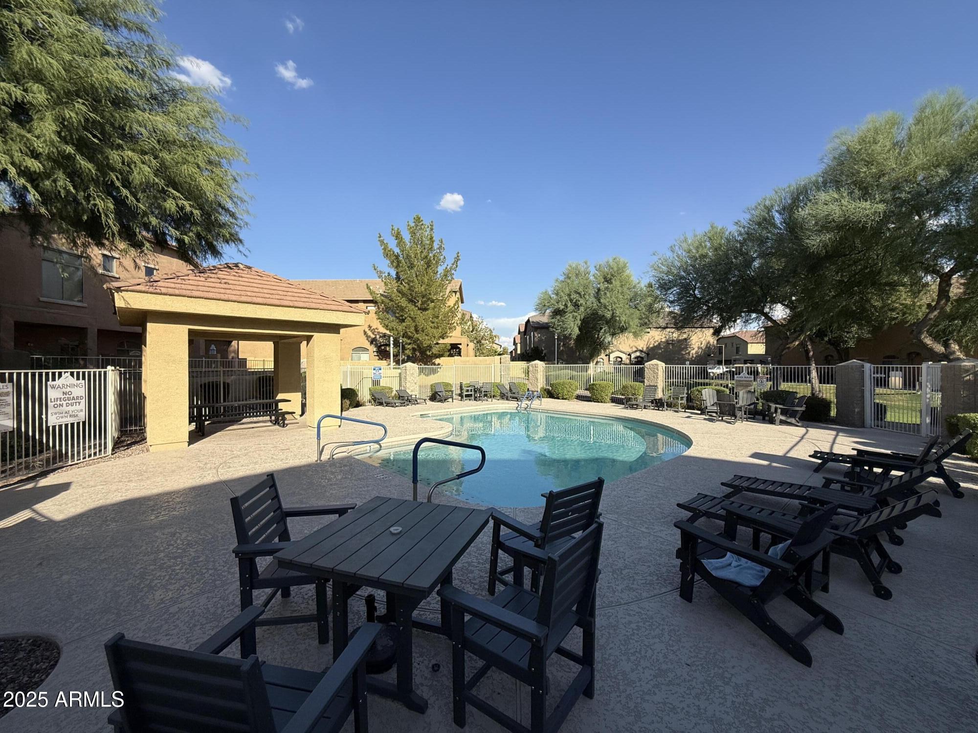 2150 East Bell Road, Unit 1138 Phoenix, AZ 85022 - Photo 37 of 38 a view of a patio with table and chairs and potted plants with large tree