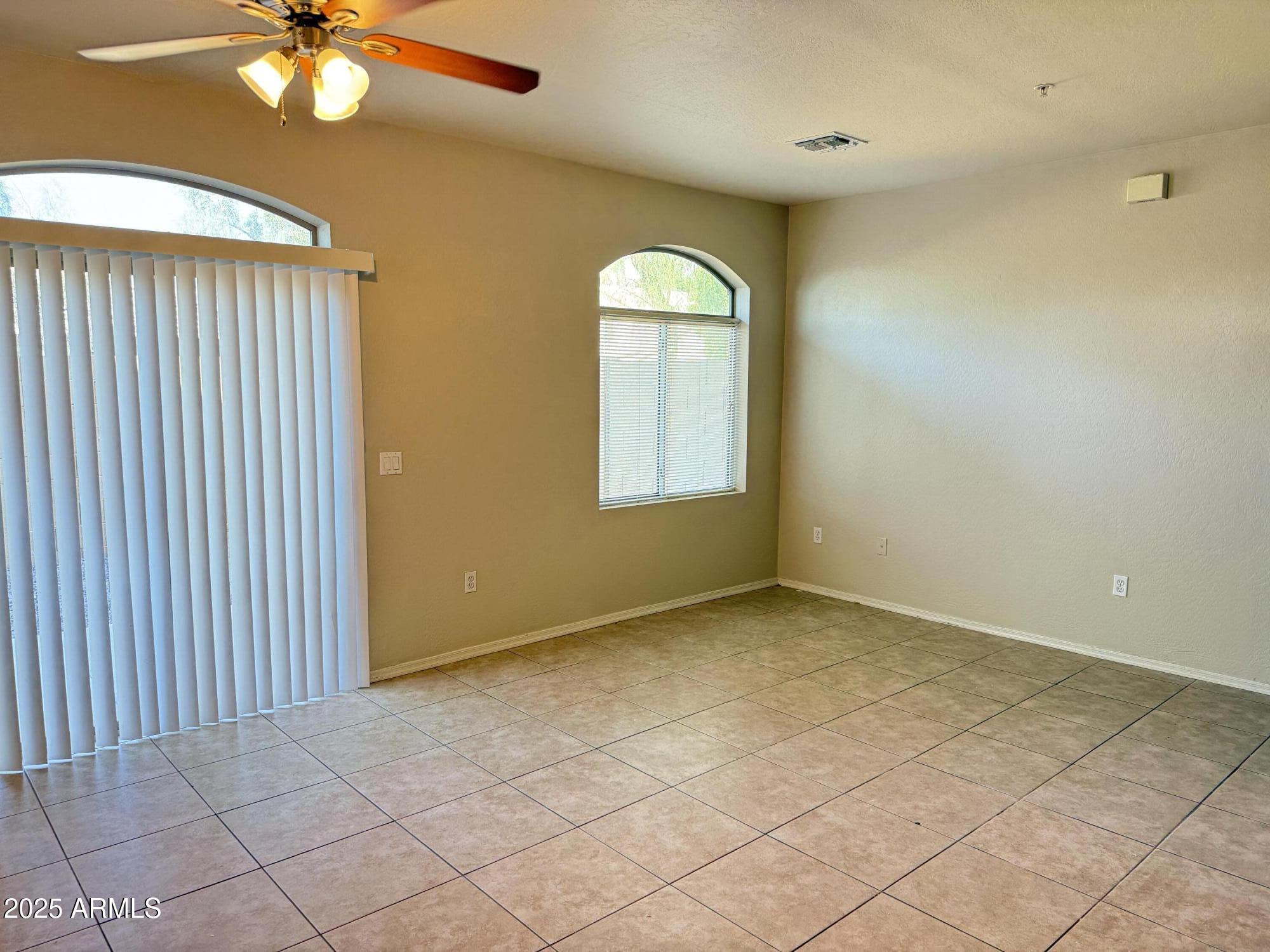 2150 East Bell Road, Unit 1138 Phoenix, AZ 85022 - Photo 6 of 38 an empty room with chandelier fan