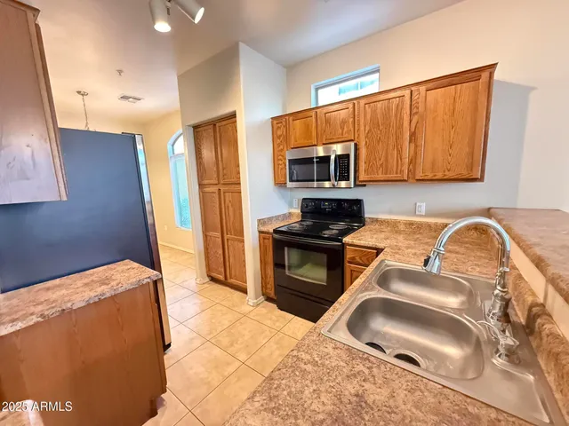 a kitchen with granite countertop a sink cabinets and stainless steel appliances