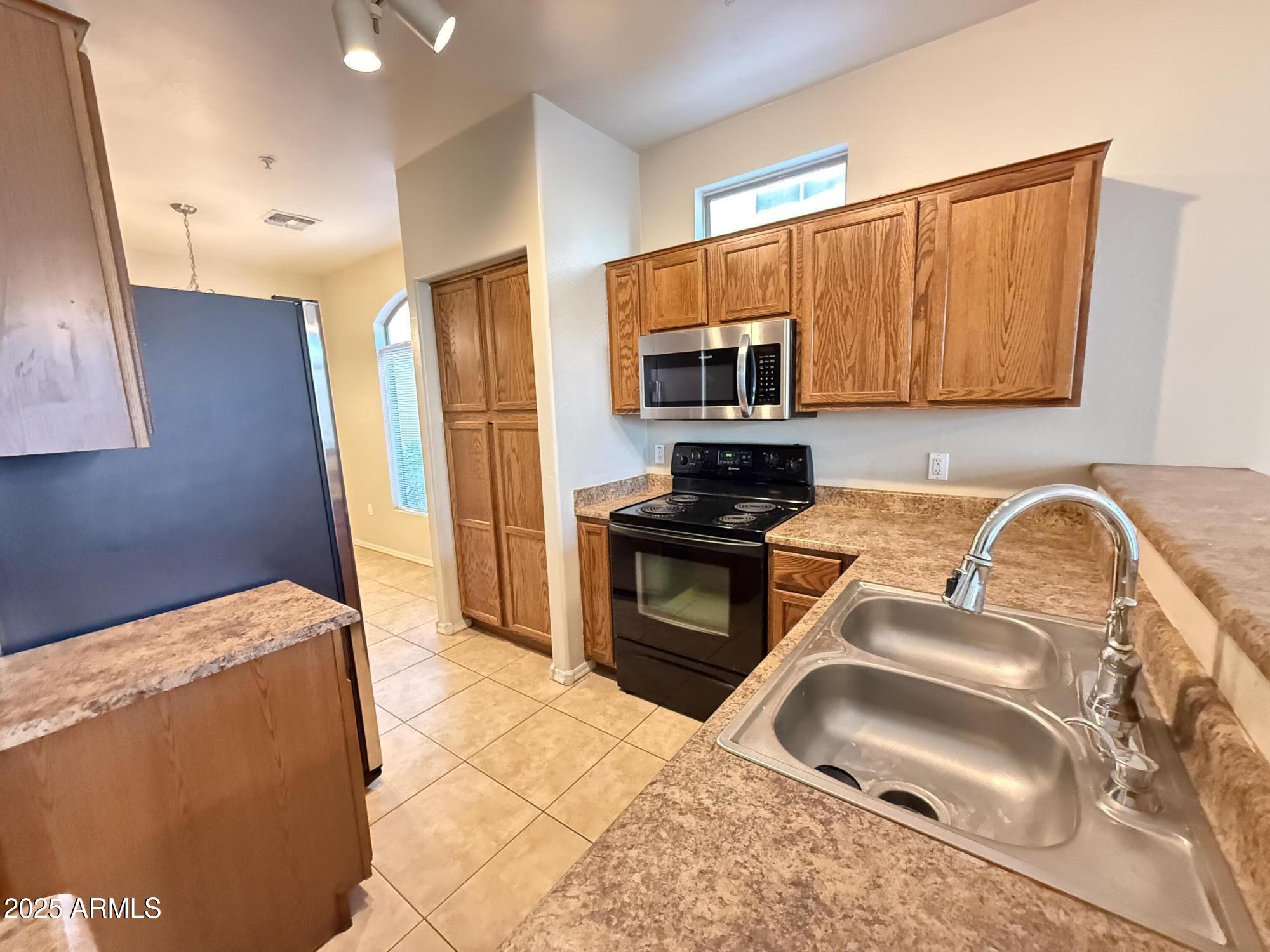 2150 East Bell Road, Unit 1138 Phoenix, AZ 85022 - Photo 9 of 38 a kitchen with granite countertop a sink cabinets and stainless steel appliances