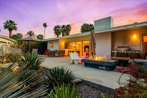 a backyard of a house with barbeque oven table and chairs