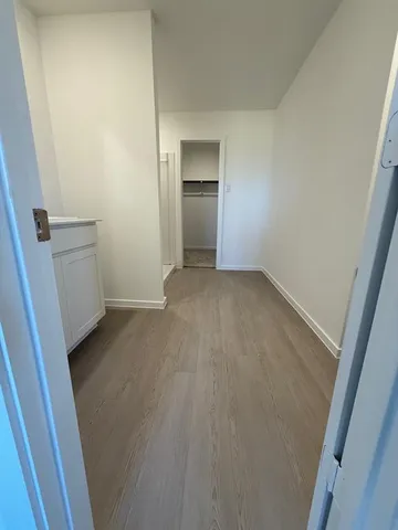 a view of empty room with wooden floor