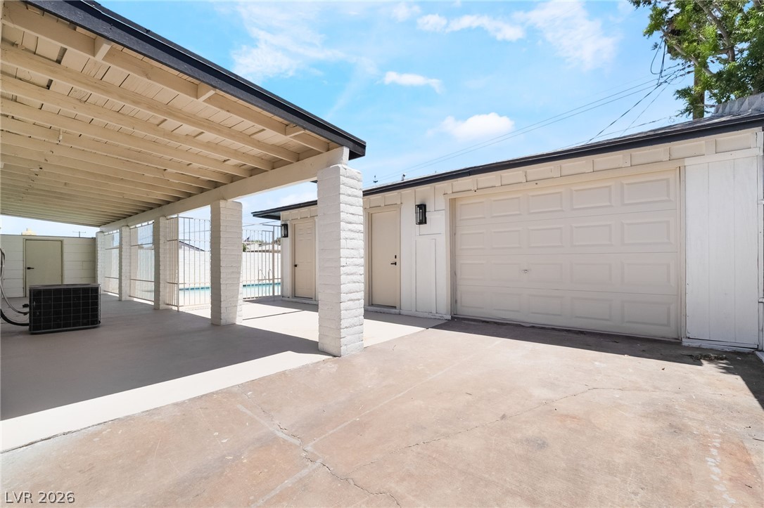 39 Lowery Street Henderson, NV 89015 - Photo 26 of 40 A spacious covered patio extends to a dedicated garage, providing ample outdoor living and vehicle storage.