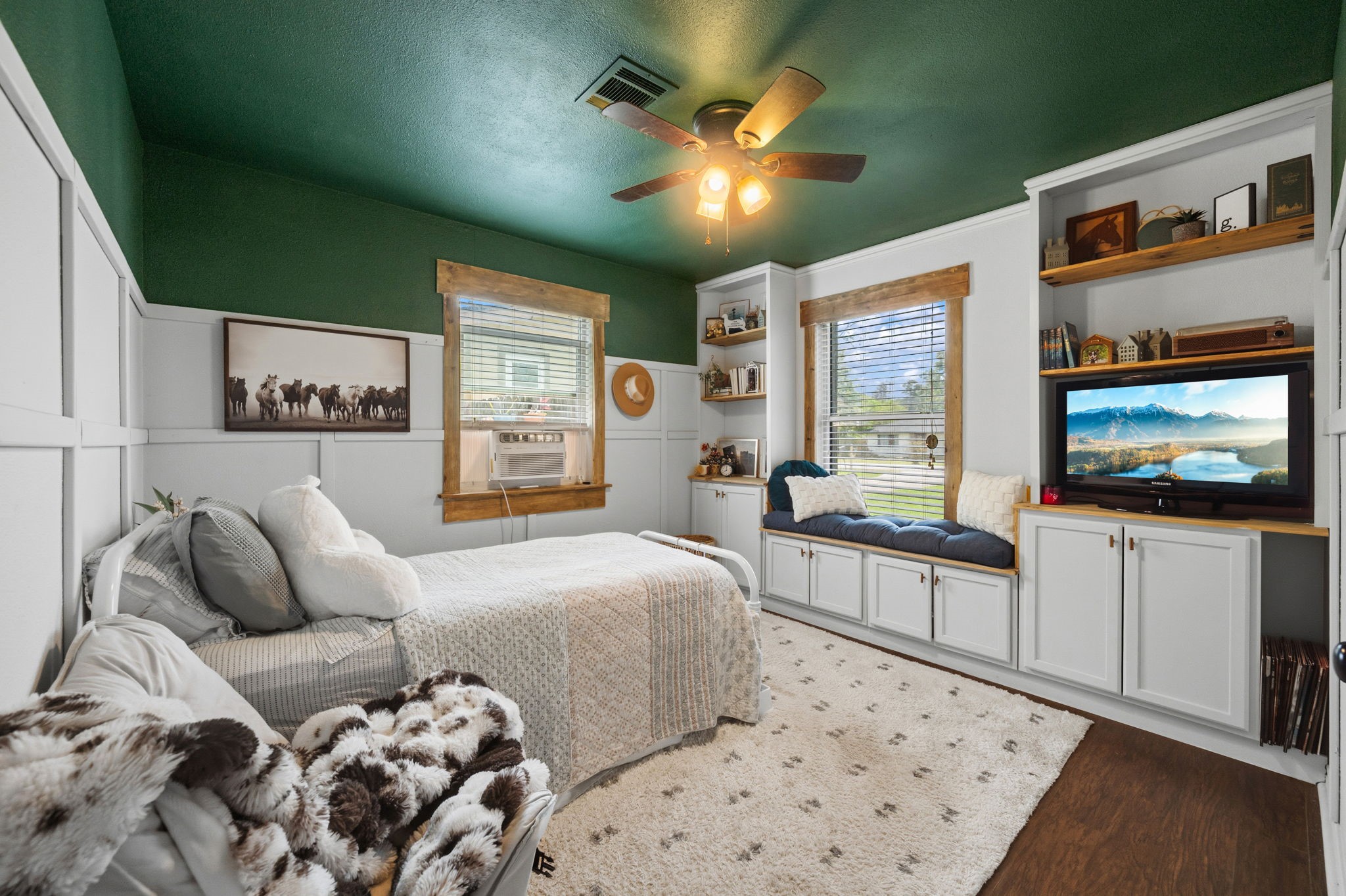 431 Corydon Drive Houston, TX 77336 - Photo 20 of 26 Cozy secondary bedroom featuring custom built-ins with shelving, cabinetry, and a charming window seat. Elegant wall paneling paired with a rich accent ceiling adds warmth and character, while natural light enhances the inviting feel.