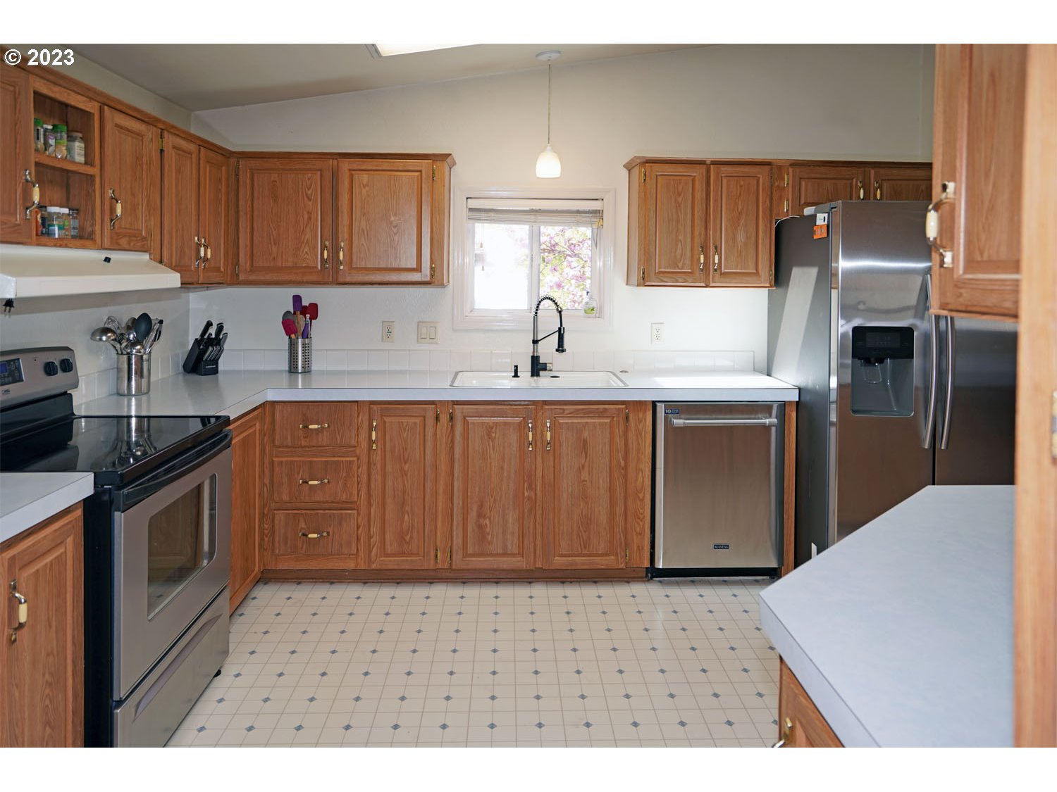 23077 Southwest Main Street, Unit 50 Sherwood, OR 97140 - Photo 16 of 24 a kitchen with kitchen island granite countertop a sink stove and refrigerator