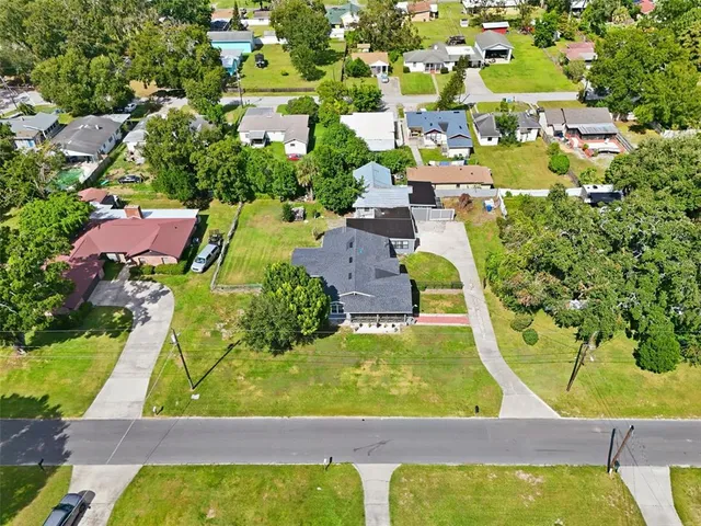 a front view of a house with a garden and lake view