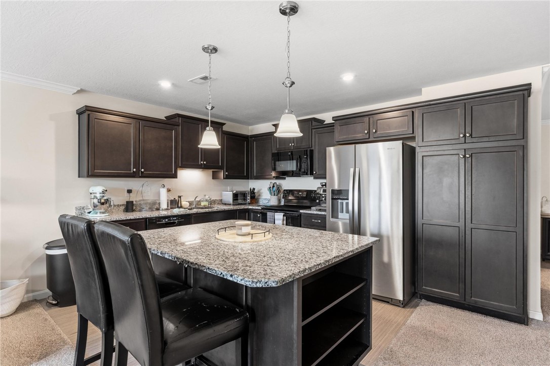 141 Old Pond Road Springboro, OH 45066 - Photo 7 of 20 This kitchen features a central island, granite counters, and stainless steel appliances.