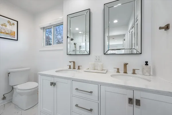 a bathroom with a toilet sink and mirror
