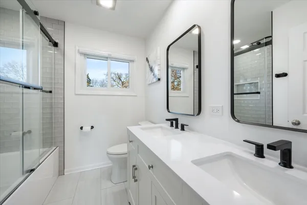 a bathroom with a sink a toilet and shower