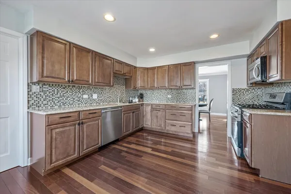 a kitchen with granite countertop wooden cabinets and white appliances