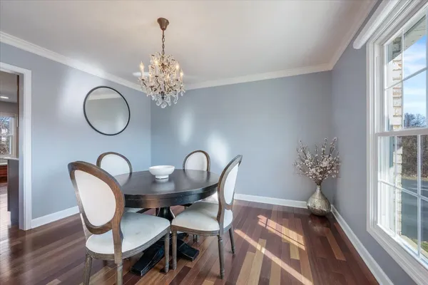 a dining room with furniture a chandelier and wooden floor