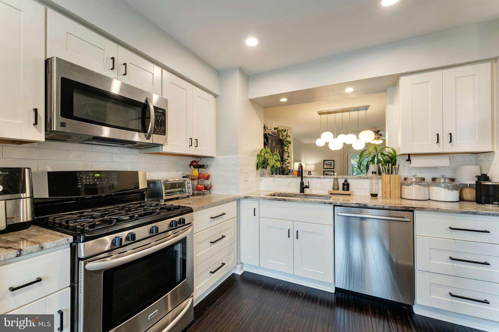 43602 Blacksmith Square Ashburn, VA 20147 - Photo 3 of 33 a kitchen with stainless steel appliances a stove microwave and sink