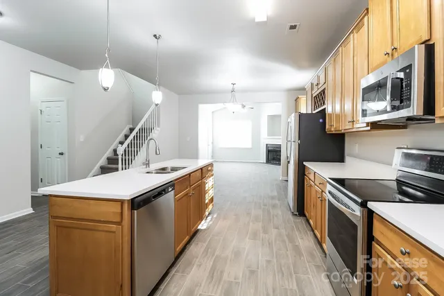 a kitchen with stainless steel appliances granite countertop a sink and a stove