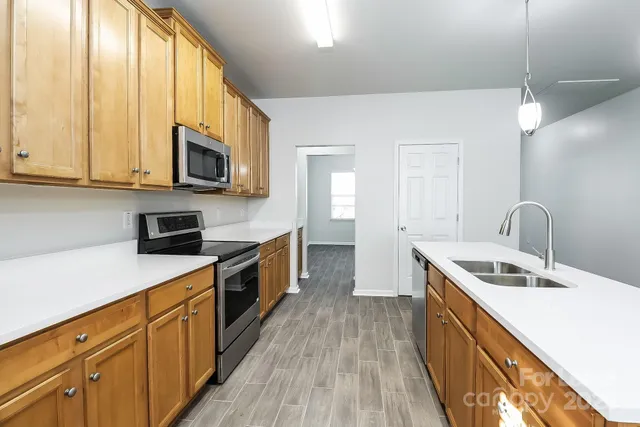 a kitchen with a sink a microwave and cabinets